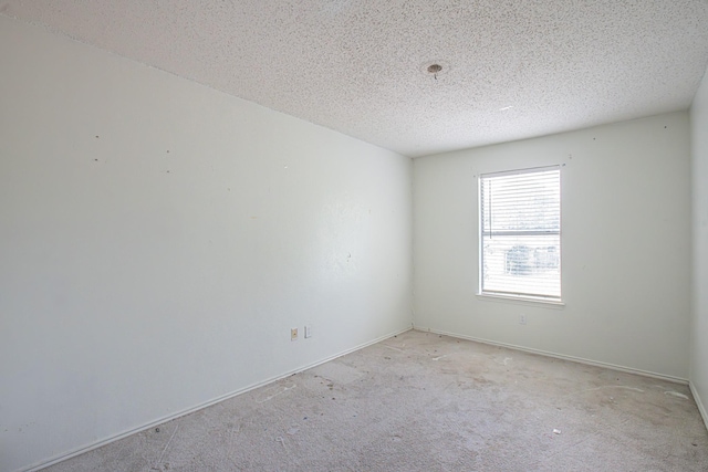 unfurnished room with light carpet and a textured ceiling