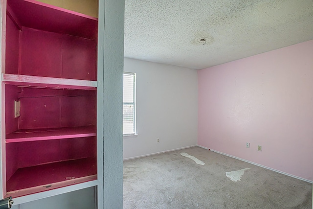 unfurnished bedroom featuring carpet floors, baseboards, and a textured ceiling
