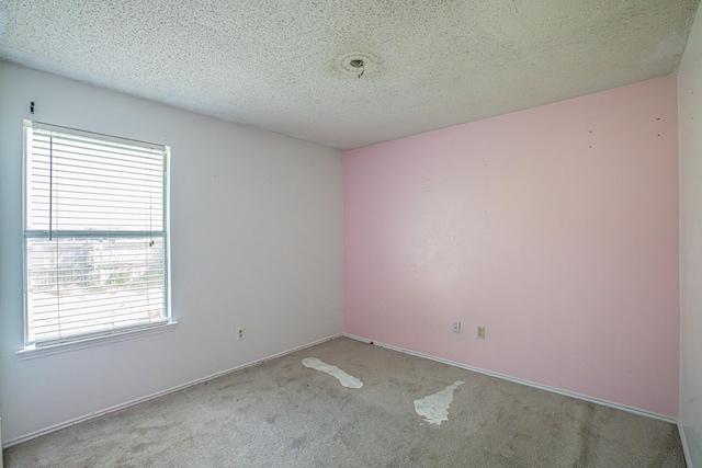 carpeted spare room with baseboards and a textured ceiling