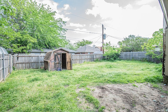 view of yard featuring a storage shed, an outbuilding, and a fenced backyard