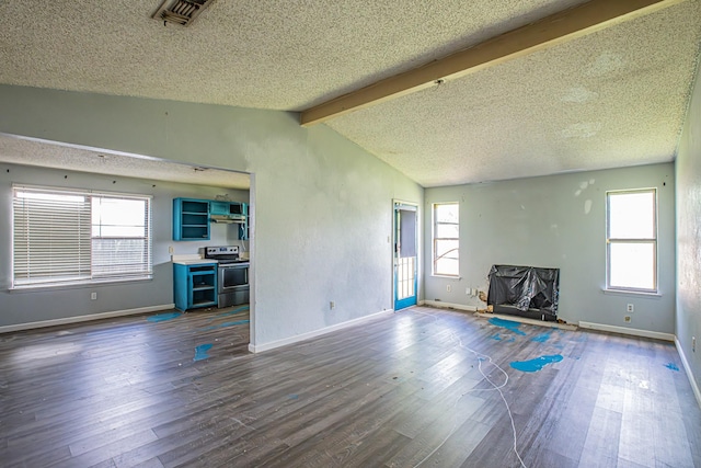 unfurnished living room with dark wood-type flooring, a textured ceiling, and baseboards