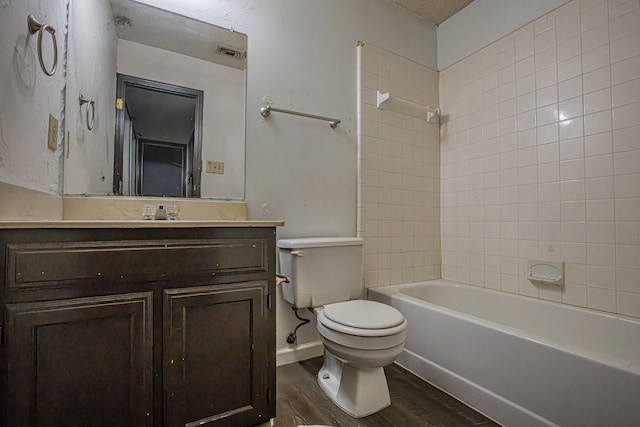 bathroom featuring wood finished floors, vanity, tub / shower combination, toilet, and visible vents