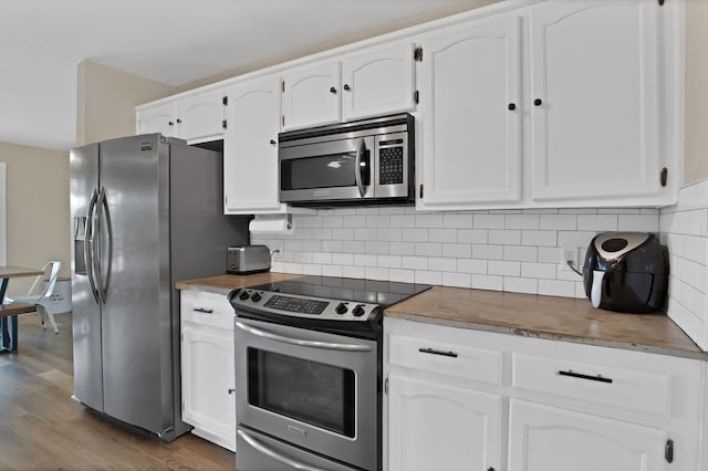 kitchen featuring dark wood finished floors, decorative backsplash, appliances with stainless steel finishes, and white cabinetry