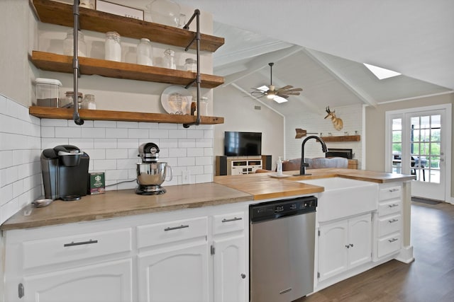 kitchen featuring white cabinets, stainless steel dishwasher, a sink, decorative backsplash, and open shelves