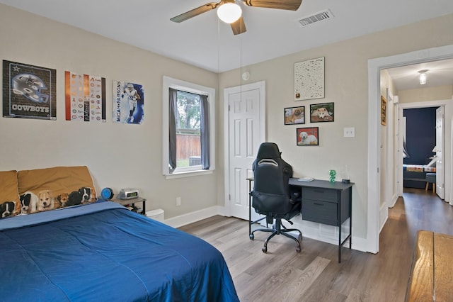 bedroom with baseboards, visible vents, wood finished floors, a closet, and ceiling fan