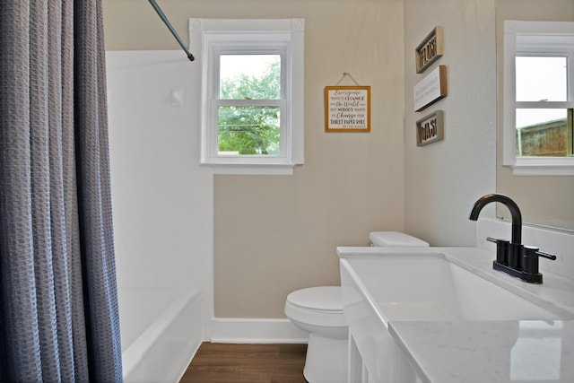 full bathroom with wood finished floors, toilet, vanity, shower / tub combo with curtain, and baseboards