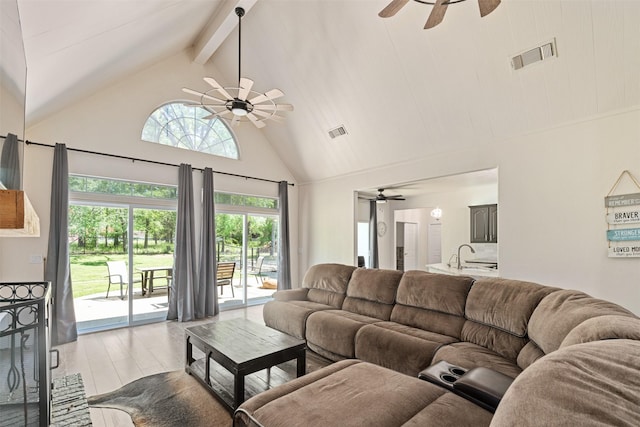 living area featuring beamed ceiling, a ceiling fan, visible vents, and high vaulted ceiling