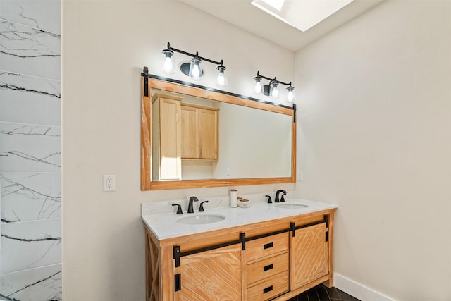 bathroom featuring double vanity, marble finish floor, baseboards, and a sink