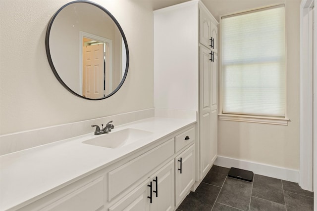 bathroom featuring baseboards, tile patterned flooring, and vanity