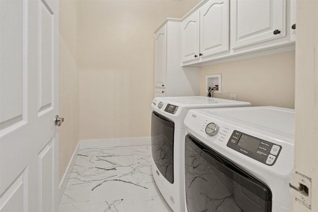 laundry area with marble finish floor, washing machine and clothes dryer, cabinet space, and baseboards