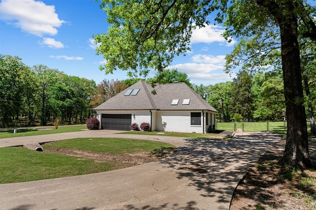 view of property exterior featuring a lawn, fence, a shingled roof, and curved driveway