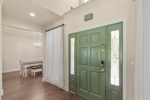entrance foyer featuring wood finished floors, baseboards, recessed lighting, and a notable chandelier