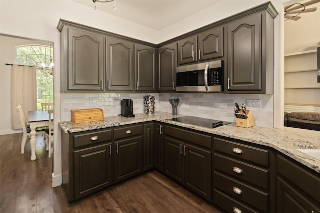 kitchen featuring stainless steel microwave, black electric cooktop, tasteful backsplash, and light stone counters