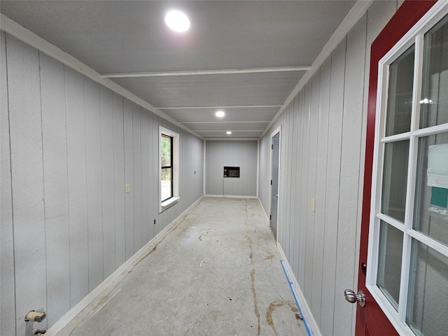 hallway featuring wood walls and baseboards