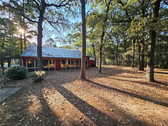 back of house with a sunroom and metal roof