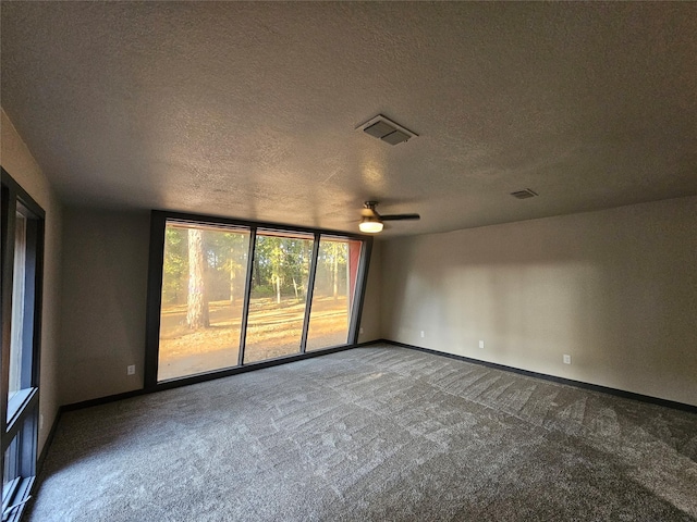 empty room with carpet floors, a textured ceiling, a ceiling fan, and baseboards