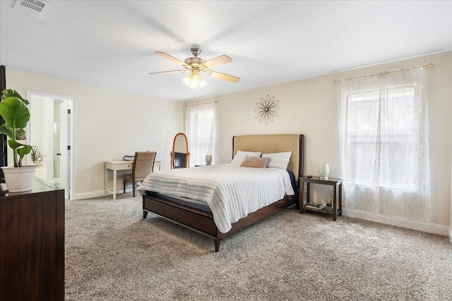 bedroom featuring visible vents, a ceiling fan, ensuite bath, baseboards, and carpet flooring