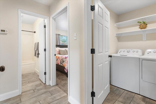 washroom with separate washer and dryer, baseboards, and wood tiled floor