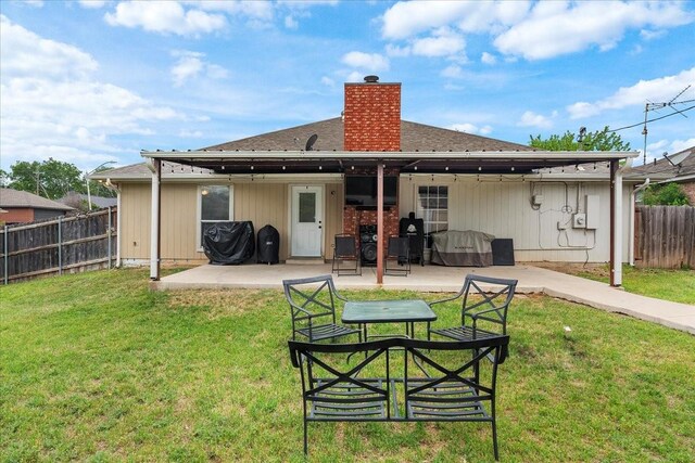 back of house with a yard, a fenced backyard, a chimney, and a patio
