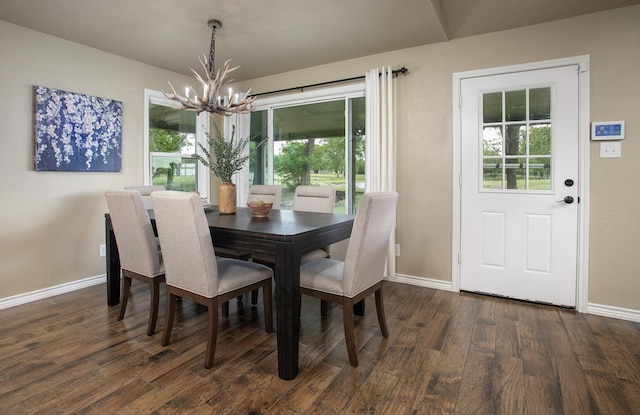 dining room with dark wood-type flooring, baseboards, and a notable chandelier