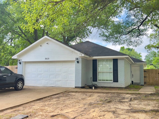 2631 Lillian St, Shreveport, LA 71103 - ranch-style house featuring roof with shingles, concrete driveway, fence, brick siding, and a garage