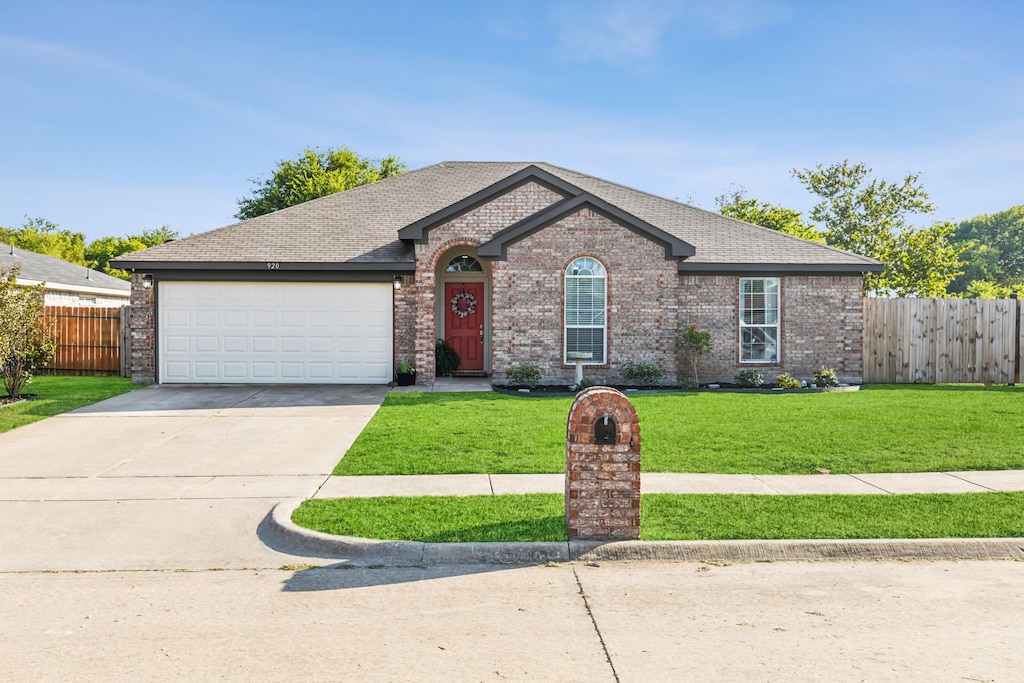 view of front of home featuring an attached garage, fence, brick siding, and concrete driveway