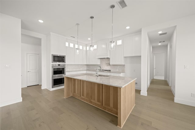 431 Broadmoor, Ovilla, TX 75154 - kitchen with appliances with stainless steel finishes, decorative backsplash, light wood-style floors, white cabinetry, and recessed lighting