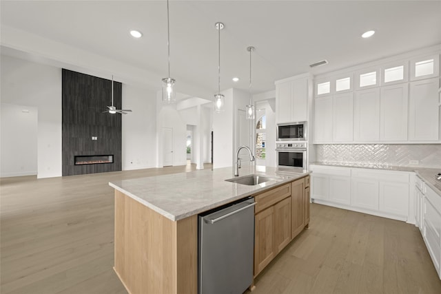 431 Broadmoor, Ovilla, TX 75154 - kitchen with a sink, stainless steel appliances, light wood-style flooring, tasteful backsplash, and recessed lighting