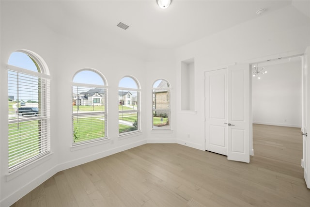 431 Broadmoor, Ovilla, TX 75154 - spare room featuring a chandelier, light wood-style flooring, and baseboards