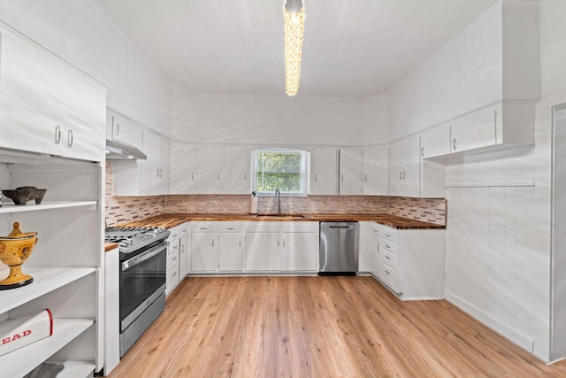 kitchen featuring white cabinets, under cabinet range hood, a sink, light wood-style flooring, and appliances with stainless steel finishes