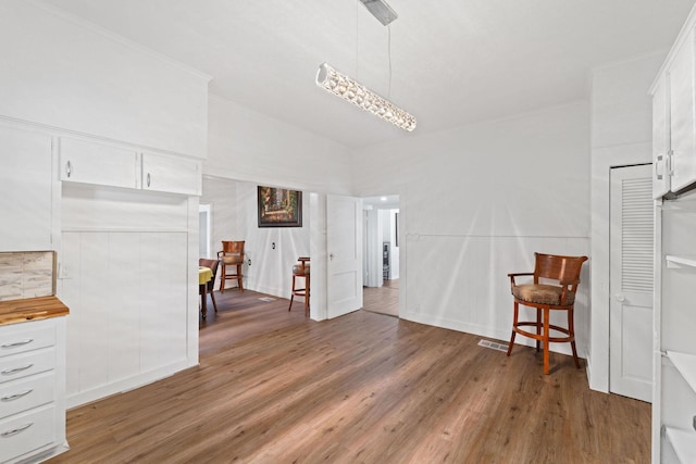 unfurnished dining area featuring ornamental molding and light wood-style flooring