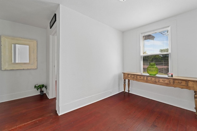 spare room featuring wood finished floors and baseboards
