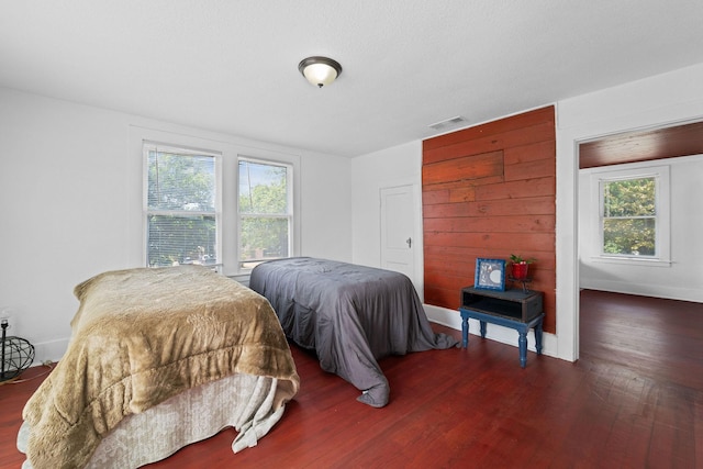 bedroom featuring wood finished floors, multiple windows, and visible vents