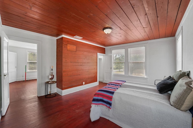 bedroom featuring visible vents, baseboards, wooden ceiling, and wood finished floors