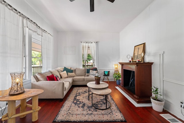 living area featuring dark wood finished floors, a ceiling fan, visible vents, and plenty of natural light