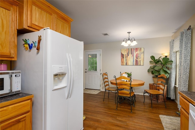 310 Otis St, Whitesboro, TX 76273 - kitchen with white appliances, dark countertops, wood finished floors, and a chandelier