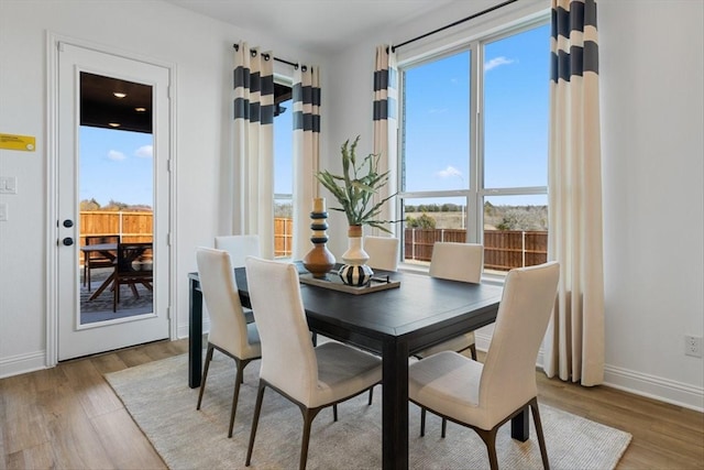 dining area with baseboards, wood finished floors, and a wealth of natural light