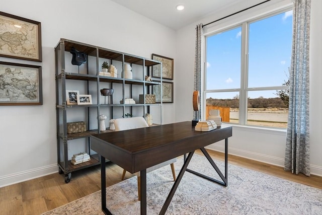 office space with recessed lighting, baseboards, wood finished floors, and a wealth of natural light