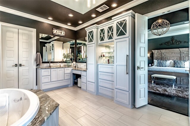 bedroom with crown molding, a raised ceiling, wood finished floors, and visible vents