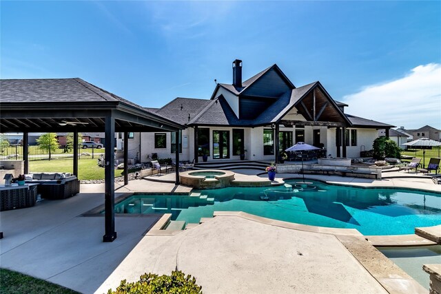 view of patio featuring a gazebo, a ceiling fan, an outdoor living space with a fireplace, and an outdoor kitchen
