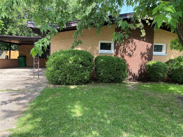 302 Meadow Dr, Gainesville, TX 76240 - view of home's exterior featuring a yard, brick siding, driveway, and an attached carport