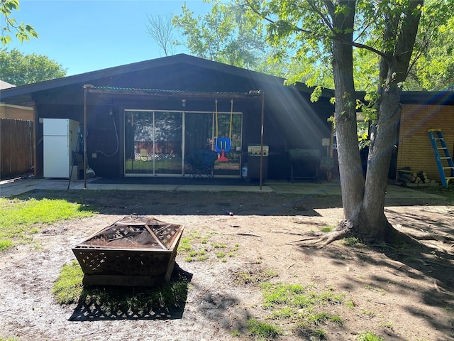 back of house with fence, an outdoor fire pit, and a patio area