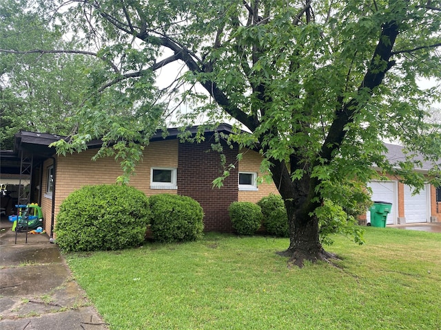 view of property exterior featuring a garage, brick siding, and a yard