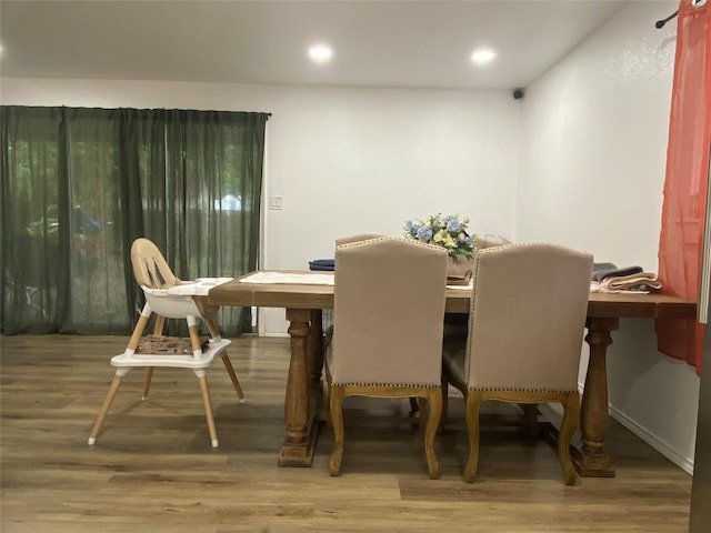 dining space with wood finished floors and recessed lighting