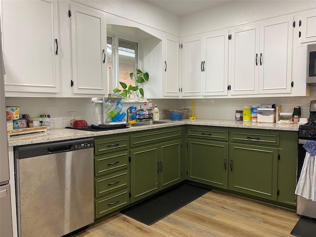 kitchen featuring white cabinetry, green cabinetry, stainless steel appliances, and light wood finished floors