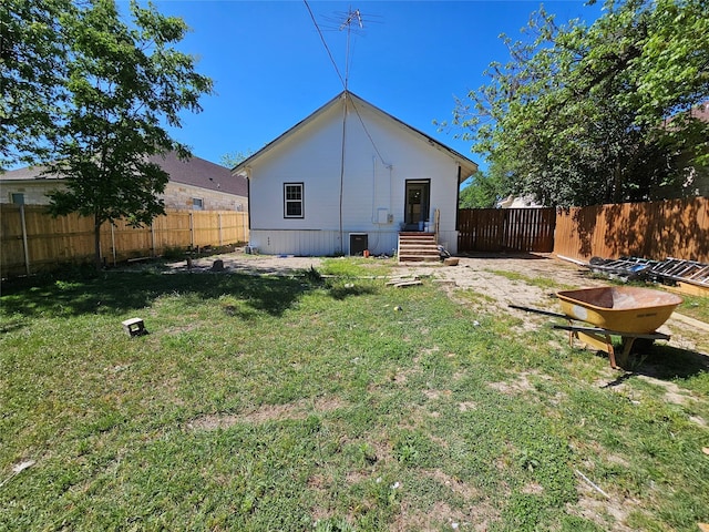 back of house featuring a lawn and a fenced backyard