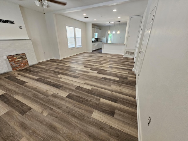 unfurnished living room featuring a ceiling fan, wood finished floors, baseboards, visible vents, and recessed lighting