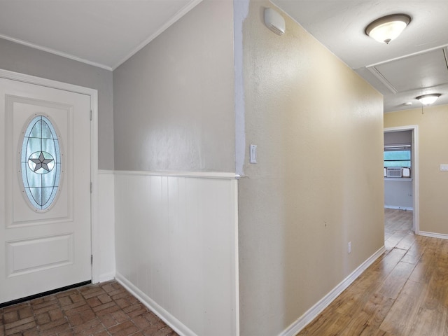 entrance foyer featuring ornamental molding, a wainscoted wall, and baseboards