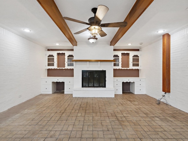 unfurnished living room featuring beamed ceiling, a ceiling fan, built in study area, and brick floor
