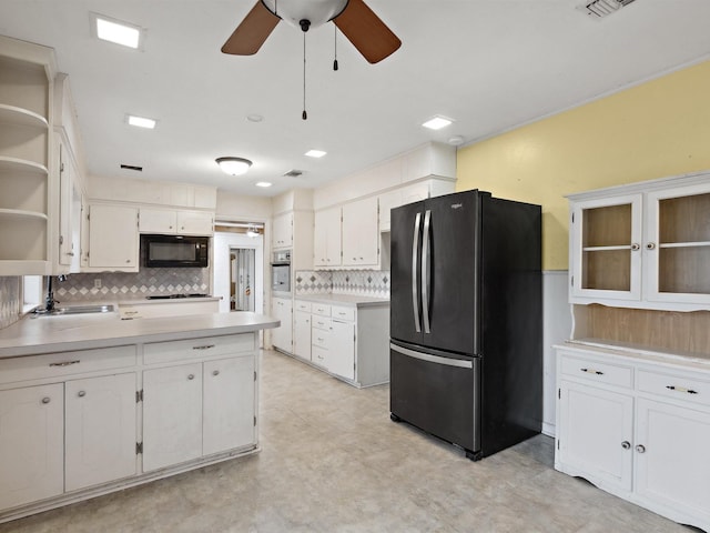 kitchen featuring black appliances, a sink, white cabinets, and backsplash